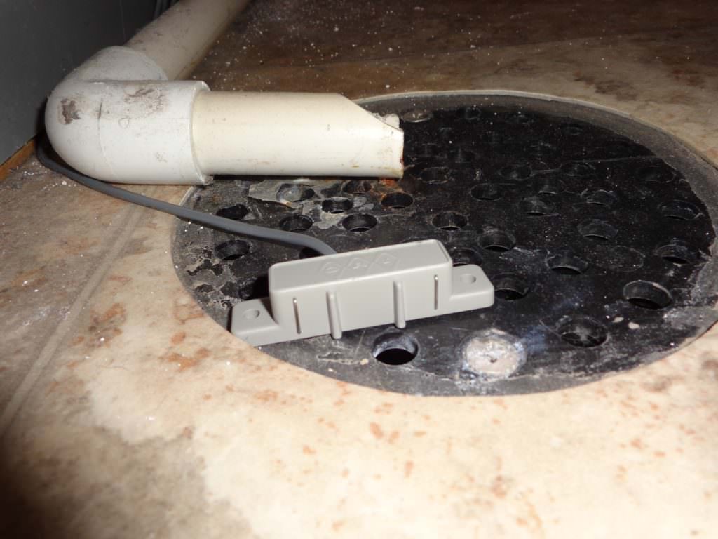 gray water sensor sitting on floor drain