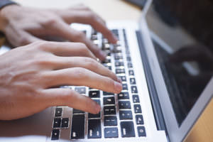 fingers typing on a laptop