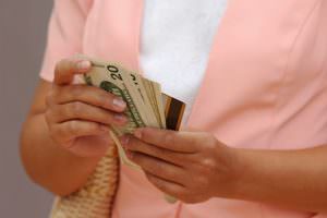 picture of a woman holding cash and a credit card