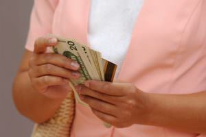 picture of a woman holding cash and a credit card
