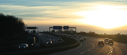 picture of cars traveling down a 6 lane highway at sunset