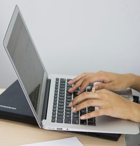 picture of someone typing on a laptop