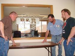 Josh Carlson of Heartland (left) goes over layouts with R & R Auto and Metal Salvage owners Chris Bickmann and Marvin Karels.