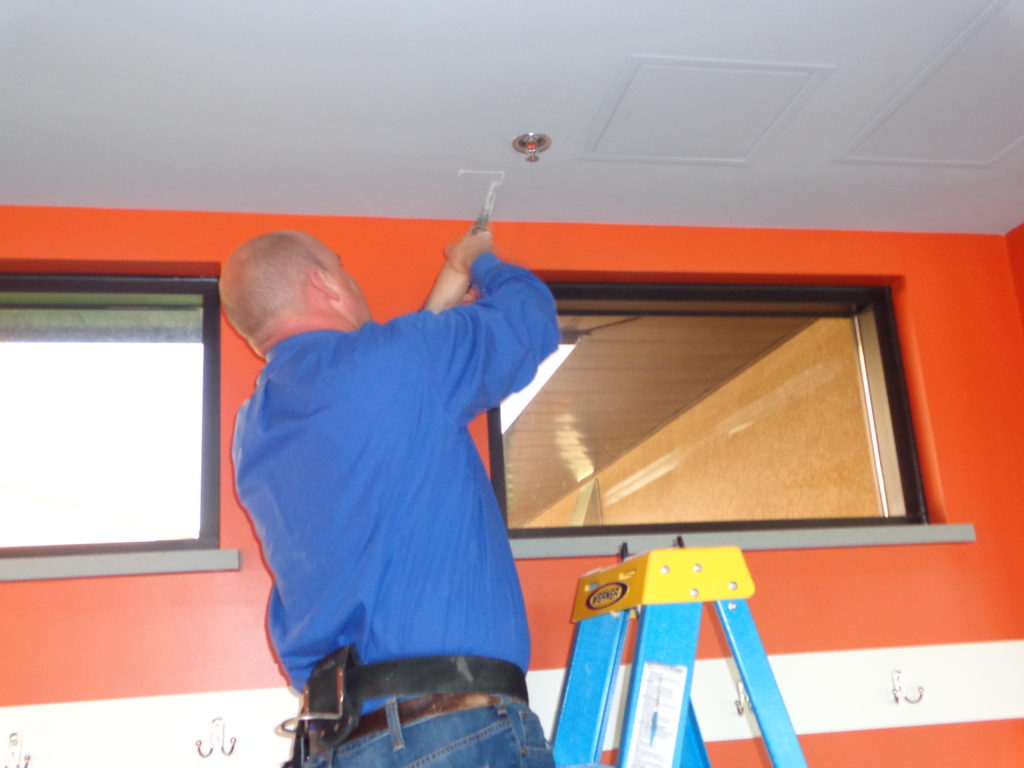 Picture of technician Josh cutting into the ceiling