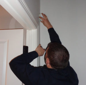 Technician Adam finishes installing a wireless motion detector.