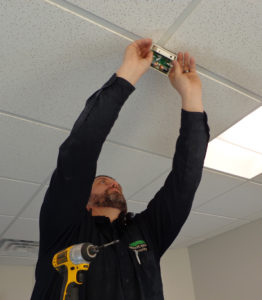 Technician Adam begins to install a glass break sensor