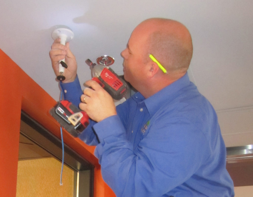 Picture of technician Josh attaching the camera mount to the ceiling